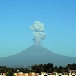 Landscape along route from Mexico City to Puebla with Popocatépetl volcano smoking on the horizon.